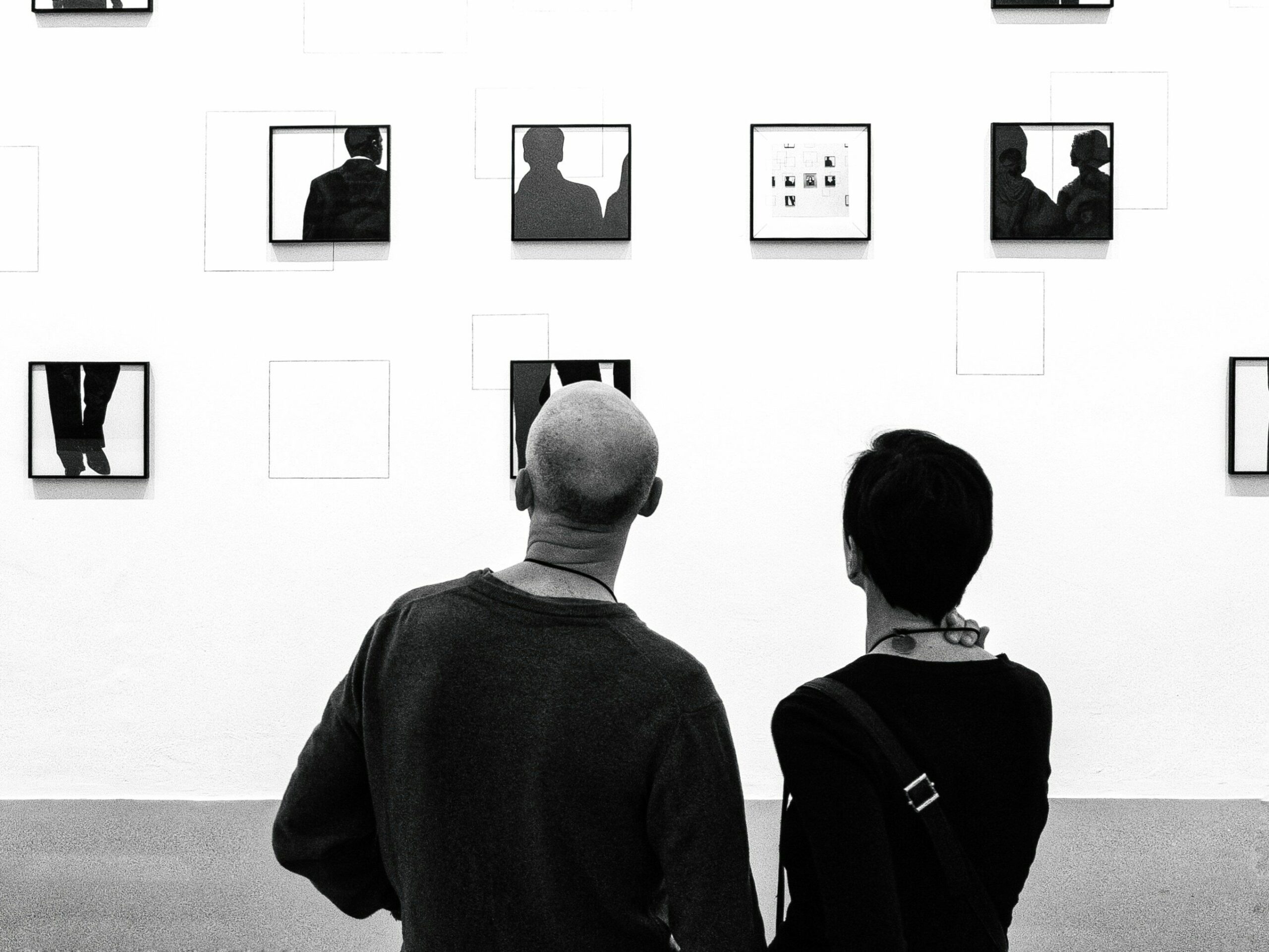 Czarno-białe dwojga ludzi oglądających obrazy w muzeum, zdjęciu towarzyszy tekst, którym jest selekcja popkulturalna czyli przegląd wydarzeń