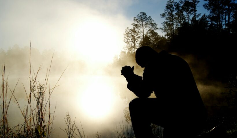 jak wrócić do modlitwy. Na zdjęciu mężczyzna siedzi w lesie i się modli