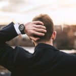 dlaczego tracę wiarę? Na zdjęciu mężczyzna patrzy na miasto, trzyma dłoń z tyłu głowy