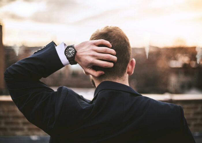 dlaczego tracę wiarę? Na zdjęciu mężczyzna patrzy na miasto, trzyma dłoń z tyłu głowy