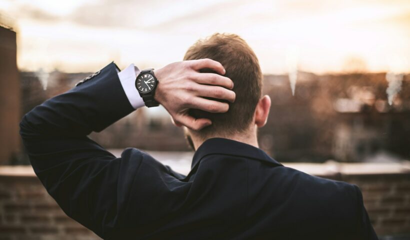 dlaczego tracę wiarę? Na zdjęciu mężczyzna patrzy na miasto, trzyma dłoń z tyłu głowy