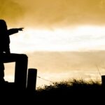 inspiracja do pisania i kreatywność w życiu codziennym, na zdjęciu zachód słońca i chłopiec wskazuje palcem świat