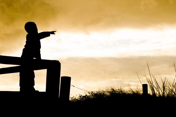 inspiracja do pisania i kreatywność w życiu codziennym, na zdjęciu zachód słońca i chłopiec wskazuje palcem świat