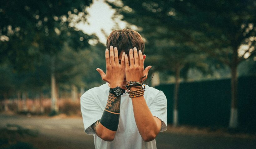 jak często chodzić do spowiedzi. Młody chłopak trzyma dłonie na twarzy.